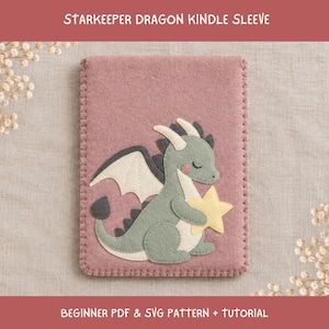 Può includere: Una custodia per Kindle in feltro rosa polvere con bordo cucito e un'applicazione di un drago verde salvia che tiene in mano una stella giallo pallido. Il testo Starkeeper Dragon Kindle Sleeve e Beginner PDF & SVG Pattern + Tutorial è visibile.