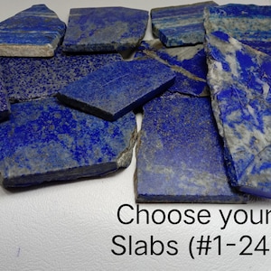 Puede incluir: Una colección de losas de lapislázuli planas y rectangulares con tonos azul profundo, vetas de calcita blanca y motas de pirita dorada. Las piedras están dispuestas en grupo y el texto Choose your Slabs (#1-24) aparece impreso debajo.