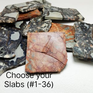 Op de afbeelding: Een verzameling onregelmatig gevormde stenen platen in verschillende kleuren, waaronder grijs, bruin en rood. De platen hebben unieke patronen en texturen. De tekst op de afbeelding luidt "Choose your Slabs (#1-36)".