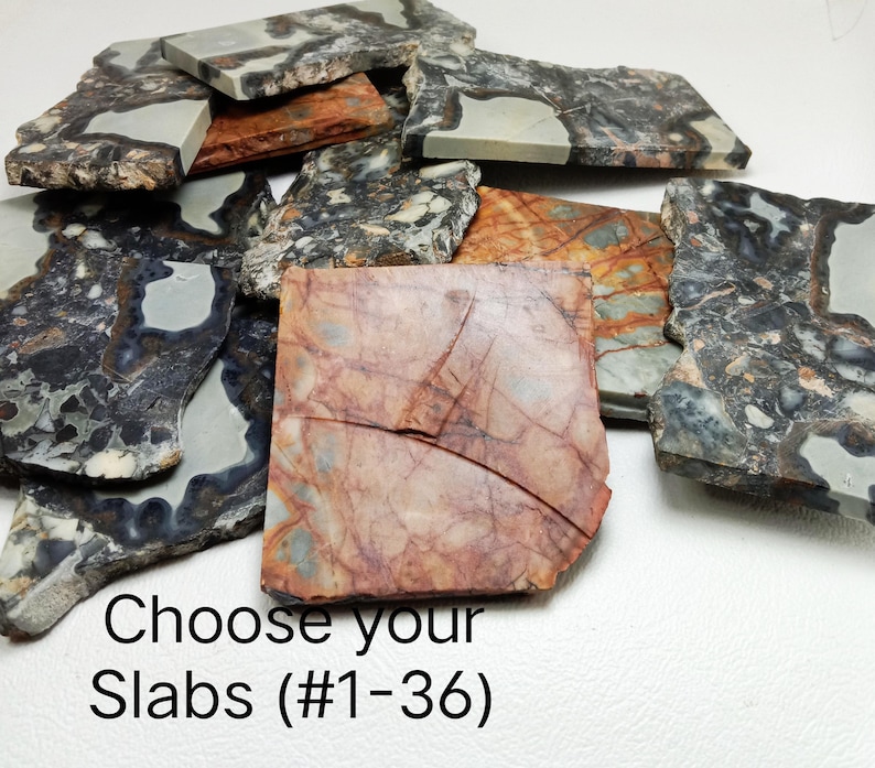 Op de afbeelding: Een verzameling onregelmatig gevormde stenen platen in verschillende kleuren, waaronder grijs, bruin en rood. De platen hebben unieke patronen en texturen. De tekst op de afbeelding luidt "Choose your Slabs (#1-36)".