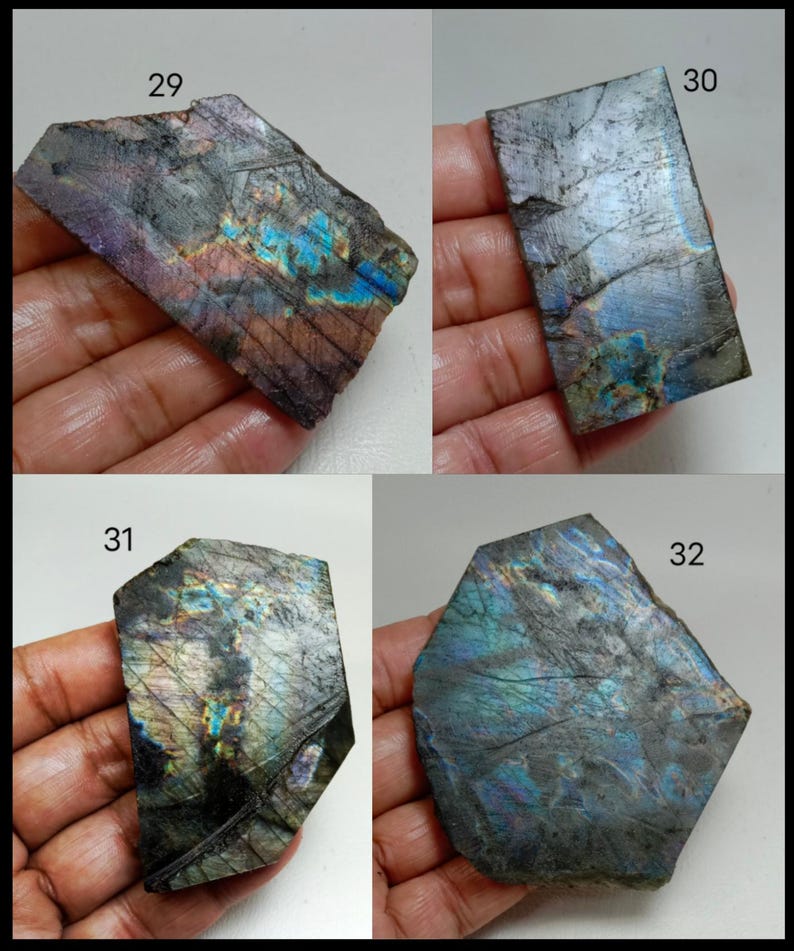 May include: Four pieces of raw labradorite gemstone, each held in a hand. The stones display a mix of dark gray, blue, purple, and iridescent colors. Each stone has a unique shape and texture, with visible natural patterns and inclusions. Numbers 29, 30, 31, and 32 are visible.