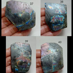 May include: Four pieces of labradorite gemstone, each with a unique shape and iridescent play of color. The stones display a range of colors, including blues, purples, and greens, with a dark gray base. Each stone is labeled with a number.
