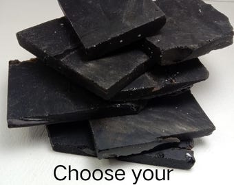 Peut inclure: Une pile de dalles de cristal noir foncé, plates et irrégulières, aux surfaces lisses et aux bords dentelés. Le texte "Choose your crystal (#1-40)" est imprimé en noir au bas de l'image, indiquant une sélection de pièces individuelles.