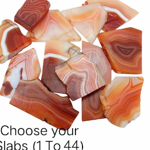 Puede incluir: Una colección de losas de ágata pulidas en tonos naranja, rojo y blanco. Las losas tienen patrones y texturas únicos con bandas. El texto en la imagen dice "Choose your Slabs (1 To 44)".