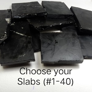 May include: A collection of irregularly shaped, black slabs. The image includes the text "Choose your Slabs (#1-40)". The slabs appear to have a glossy finish and vary in size and shape.