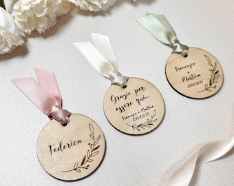 Peut inclure: Trois étiquettes rondes en bois avec une finition en bois naturel et un motif gravé brun. Les étiquettes sont attachées avec un ruban rose, blanc et vert. Le texte sur les étiquettes est "Federica", "Grazie per essere qui... Francesco e Martina 29/07/2025", et "Francesco e Martina 29/07/2025".