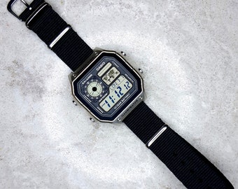 Reloj Casio World Time Illuminator plateado con correa de nailon negra, AE-1200WHD-1AVEF
