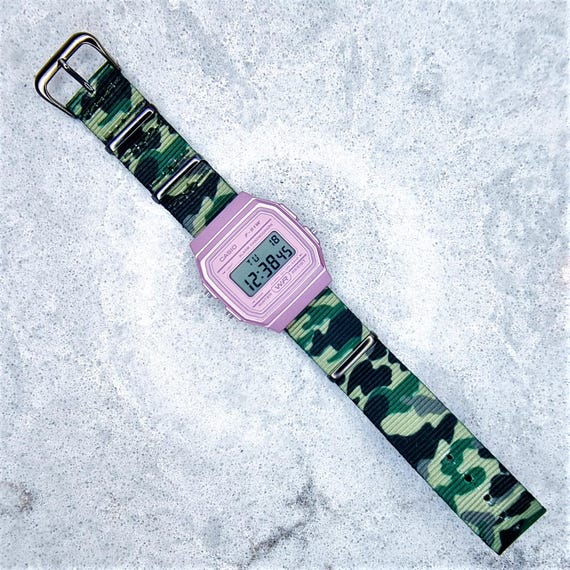 Klassische Casio F91W Metallic Pink Uhr auf einem Jungle Camo Nylon Strap  Band