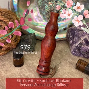 Könnte beinhalten: Ein handgeschnitzter persönlicher Aromatherapie-Diffusor aus Bloodwood. Der Holzdiffusor hat eine satte rotbraune Farbe und eine einzigartige, geschwungene Form. Der Diffusor gehört zur Elite Collection.