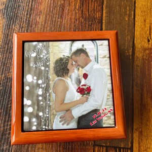 May include: A wooden box with a photo of a couple in front of a white brick wall. The photo is of a bride and groom, and the text "Georgia & Steven 10.16.19 Las Vegas, NV" is printed on the photo.