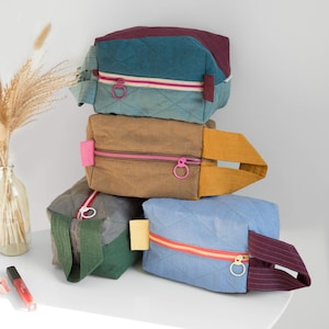 Gesteppte Tasche aus mehrfarbigem Leinen mit buntem Reißverschluss. Kastige Reise-Kulturtasche.