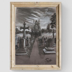 May include: A framed grayscale watercolor painting of a cemetery with a church in the background. The artwork is signed in the lower right corner. The painting hangs above a gray dresser with a plant and a decorative bowl.