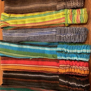 May include: A set of ten colorful striped headbands with elastic backings. The headbands are made of woven fabric and feature a variety of colors and patterns.
