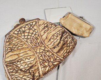 May include: A gold beaded evening bag with a matching gold coin purse. The bag features a decorative design of geometric shapes and floral motifs.