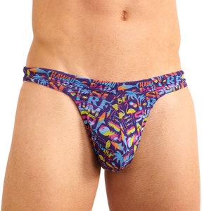 Könnte beinhalten: Lilafarbener Tanga mit einem bunten tropischen Muster mit Palmen, Flamingos und den Worten "Hawaii" und "Paradise".