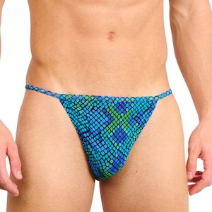 May include: A blue, green, and black patterned thong swimsuit. The swimsuit has a snake-like scale design. The string straps are blue. The swimsuit is made of a stretchy material.