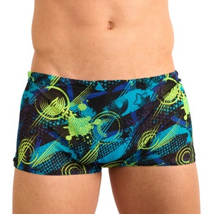 Puede incluir: Bañador negro con un patrón geométrico en tonos de azul, verde y amarillo. El patrón incluye círculos, rayas y salpicaduras.