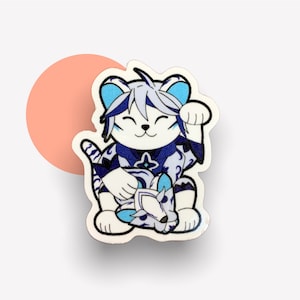 Op de afbeelding: Witte en blauwe keramische figuur van een kat met een opgeheven poot in een wenkende houding. De kat draagt een blauw-witte gepatenteerde kimono.