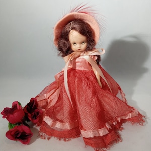 Vintage Nancy Ann storybook doll, 1950s series collectible, dressed in reddish orange, felt and feathered hat