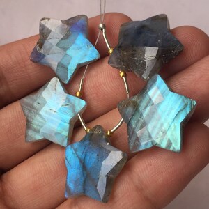 May include: Five iridescent blue labradorite gemstone star-shaped beads with a silver wire threaded through each bead.