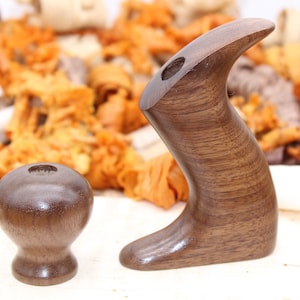 May include: Two wooden handles for a hand plane, one is a knob and the other is a longer handle. Both are made of dark brown wood.