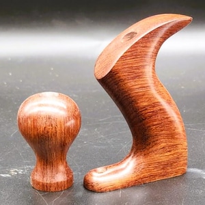 May include: Two wooden hand planes with a reddish-brown finish. The larger plane has a curved handle and the smaller plane has a round knob.