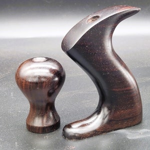 May include: Two wooden handles for a hand plane. The handles are dark brown and have a smooth, polished finish.