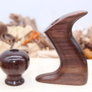May include: A set of two wooden hand plane handles made of dark brown wood. The handles are smooth and polished, with a natural wood grain visible. The handles are designed to be comfortable to grip and use.