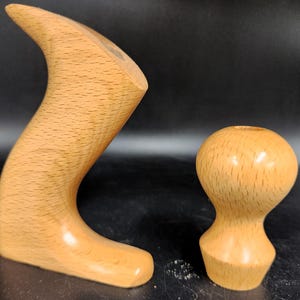 May include: Two wooden hand planes with a natural finish. The larger plane has a curved handle and the smaller plane has a round knob.