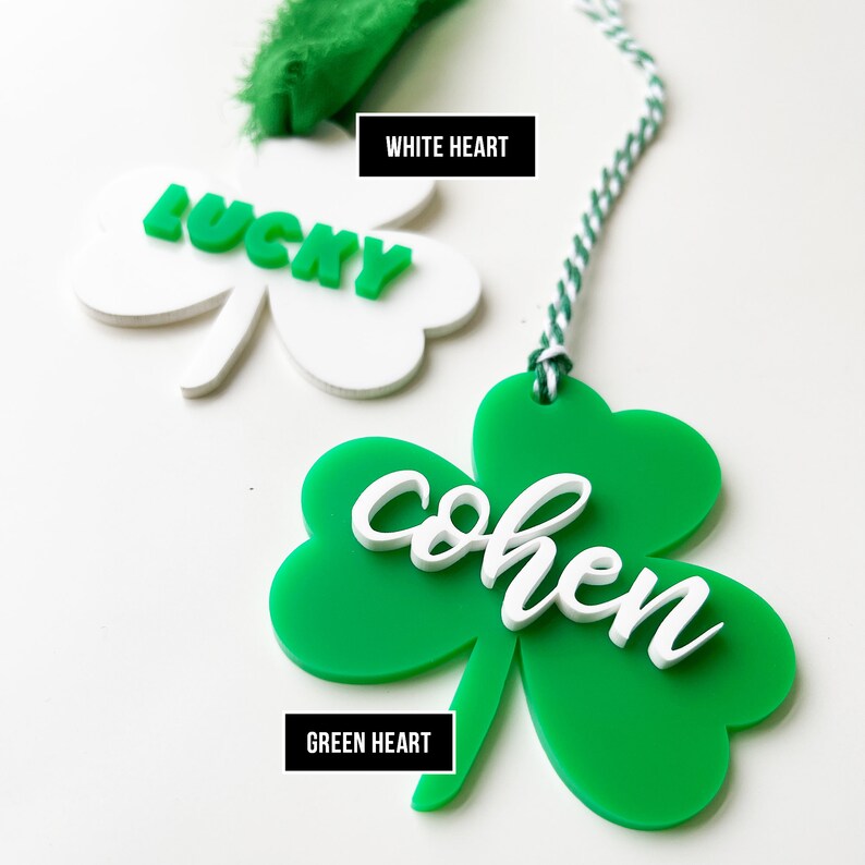 Pu&ograve; includere: Due ornamenti a forma di trifoglio, uno bianco con la parola "LUCKY" in lettere verdi e uno verde con la parola "cohen" in lettere bianche. Il trifoglio verde ha un cordino bianco.