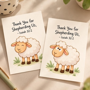 May include: Two rectangular greeting cards featuring a cartoon illustration of a white sheep standing in green grass. The text on each card reads, Thank You for Shepherding Us, - Isaiah 32:2, printed in a simple black sans-serif font.