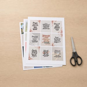 Puede incluir: Hojas de tarjetas impresas con citas religiosas, como "La oración no necesita palabras perfectas" y "Jehová está cerca". Las tarjetas tienen un diseño de acuarela con acentos rosas y beige. Un par de tijeras está al lado.