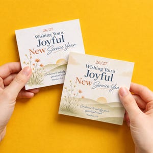 May include: Two square white cards featuring the text '26/27 Wishing You a Joyful New Service Year' in blue and orange. The design includes watercolor illustrations of wildflowers, rolling hills, a sun, and the verse 'Continue to satisfy your spiritual need. Matthew 5:3'.