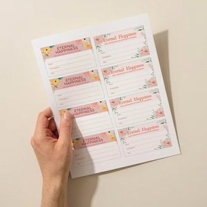 Puede incluir: Una hoja de papel con varias tarjetas de eventos, cada una con el texto "Eternal Happiness" en un marco floral decorativo. Las tarjetas tienen espacios para nombres y otros detalles, con un fondo rosa pálido.