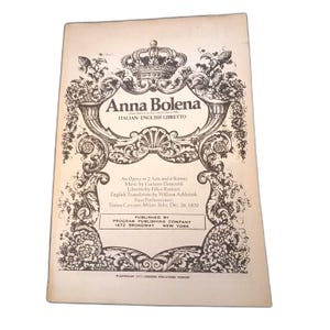 May include: A vintage opera libretto for Anna Bolena, featuring black text and ornate floral illustrations on a cream-colored cover. The title, composer Gaetano Donizetti, librettist Felice Romani, and publication details from 1472 Broadway are printed.