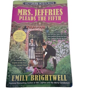 May include: Book cover for "Mrs. Jeffries Pleads the Fifth" by Emily Brightwell. The cover features a woman in a maid's uniform and a man in a suit, both looking surprised. The book is part of the Victorian Mysteries series and is described as "murder most English".