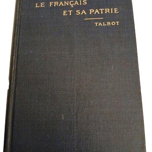 May include: A vintage book with a dark blue cover. The title "LE FRANÇAIS ET SA PATRIE" and the author's name "TALBOT" are printed in gold lettering. The book's cover has a textured appearance, suggesting it is made of cloth.