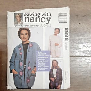 May include: A sewing pattern envelope featuring a woman in a blue patchwork jacket with pink floral accents. The envelope reads "sewing with nancy" and includes pattern details like "Crazy Patchwork" and "Dimensional Ruching."
