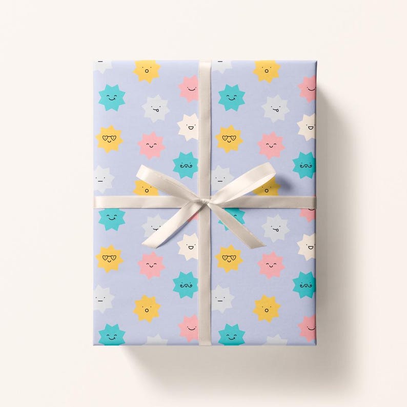 May include: Gift wrapped in light purple paper with a repeating pattern of smiling starbursts in yellow, teal, pink, and white. A white ribbon is tied around the package in a bow.