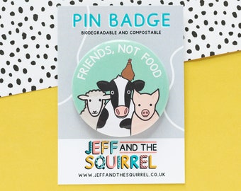 May include: A round pin badge with the text "FRIENDS, NOT FOOD" and illustrations of a sheep, cow, pig, and chicken. The badge is on a card with the text "PIN BADGE" and "JEFF AND THE SQUIRREL". The background is yellow and white with black polka dots.
