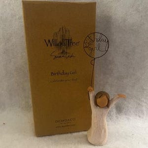 May include: A small wooden figurine of a girl holding a balloon that says "Birthday Girl". The figurine is wearing a white dress and has brown hair. The box the figurine is in says "Willow Tree" and "Birthday Girl Celebrate your day!"