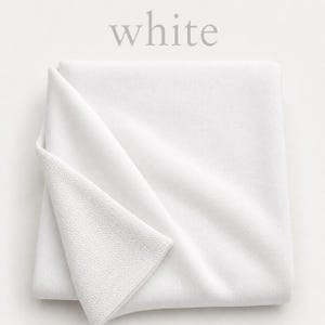May include: A folded square of solid white fabric with a visible knit texture. The top corner is turned over to reveal the reverse side of the material. The word white is printed in a light gray serif font above the folded textile.
