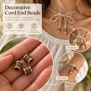 Pode incluir: Contas decorativas para extremidades de cordão com formato cilíndrico, acabamento em ouro metálico e detalhes pretos em baixo-relevo. As contas apresentam um padrão texturizado de linhas onduladas e pequenos pontos. Aplicadas em colar e pulseira.