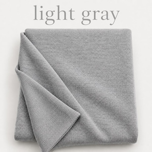 May include: A folded piece of light gray fabric with a smooth, uniform texture on the top layer and a visible knit pattern on the underside. The text light gray is printed in a simple serif font above the fabric.