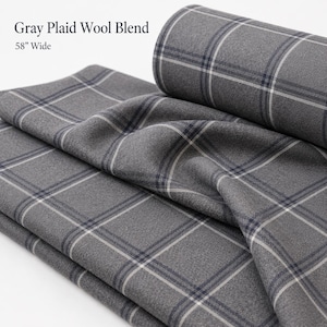 May include: A gray plaid wool blend fabric featuring a dark gray and white grid pattern. The textile is rolled and folded, displaying a textured surface. Text on the image reads: Gray Plaid Wool Blend, 58" Wide. The fabric has a consistent weave.