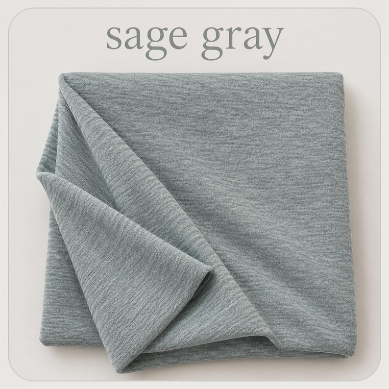 May include: A folded piece of sage gray fabric with a fine, textured knit surface. The material displays a soft, heathered appearance with subtle horizontal lines throughout the weave. The text sage gray is printed above the fabric.