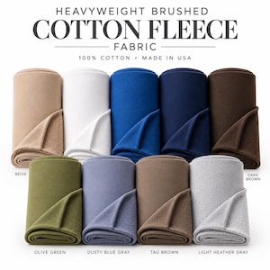 May include: Heavyweight brushed cotton fleece fabric in ten colors including beige, white, blue, navy, dark brown, olive green, dusty blue gray, taupe brown, and light heather gray. The text reads HEAVYWEIGHT BRUSHED COTTON FLEECE FABRIC 100% COTTON MADE IN USA.
