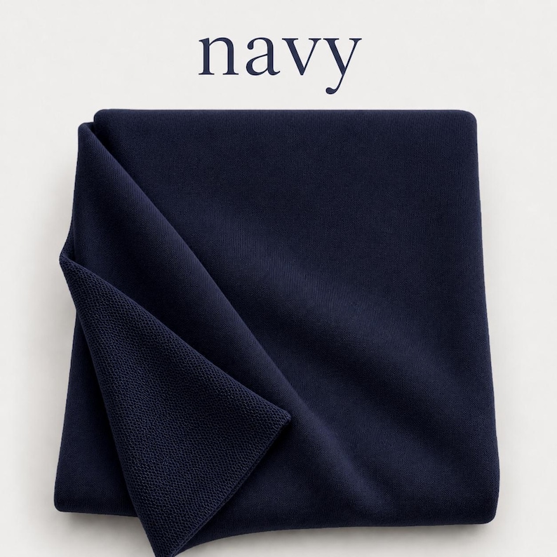 May include: A folded navy blue textile with a visible knit texture. The word navy is printed in dark blue letters above the fabric. The fabric has a smooth surface on one side and a textured, looped knit pattern on the folded corner.