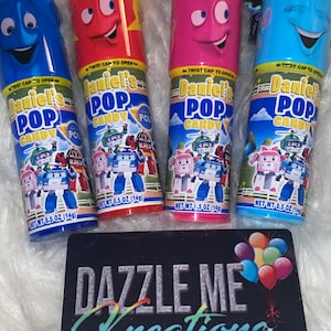 May include: Four colorful plastic tubes of Daniel's Pop Candy. Each tube has a cartoon face on the front and a picture of a robot on the back. The tubes are labeled "Daniel's Pop Candy" and "Net Wt. 0.5 oz (14g)".
