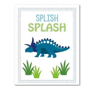 May include: A white rectangular print with a blue dotted border. The print features a blue dinosaur illustration with the words "SPLISH SPLASH" in blue and green. Green grass illustrations are at the bottom.